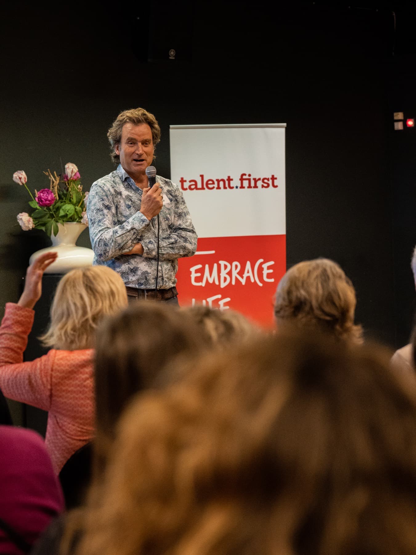 Huub van Zwieten op het podium met microfoon