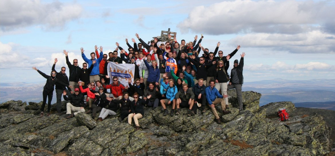 TalentFirst team op bergtop met vlag